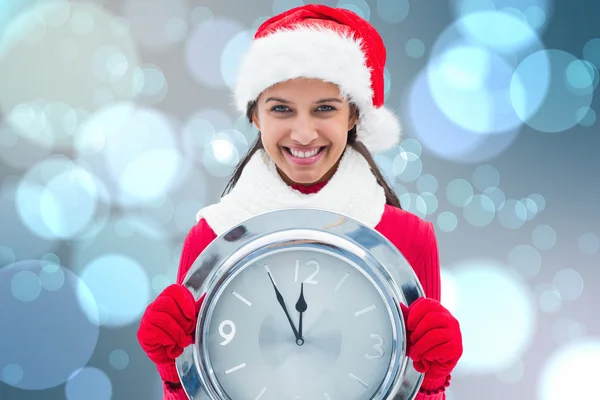 Zusammengesetzte Bild der festlichen Brünette, die Uhr hält — Stockfoto