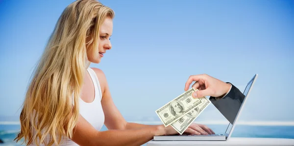 Blonde met behulp van haar laptop op het strand — Stockfoto