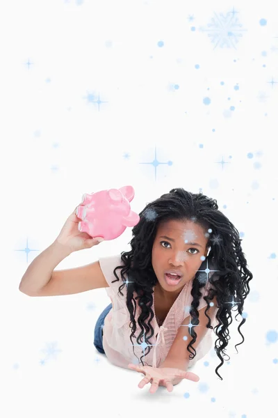 Bezorgd jonge vrouw met een lege piggy bank — Stockfoto