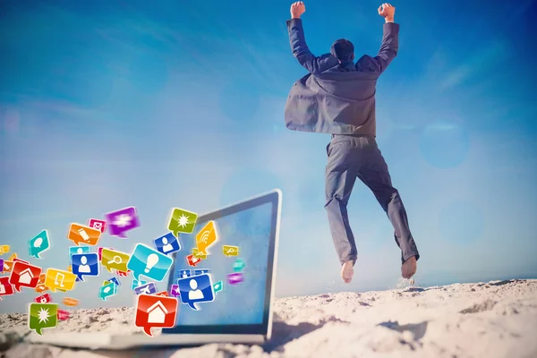 Businessman jumping on beach — Stock Photo, Image