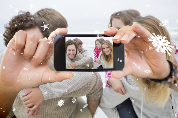 Composite image of hand holding smartphone — Stock Photo, Image