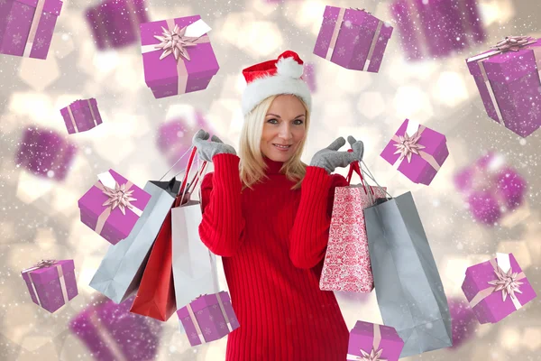 Imagen compuesta de la rubia festiva feliz con bolsas de compras — Foto de Stock