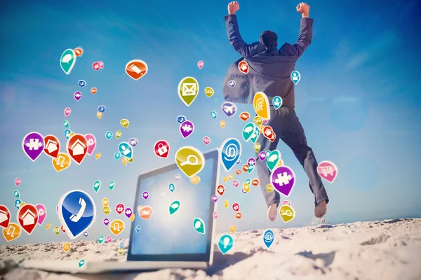 Businessman jumping on beach — Stock Photo, Image