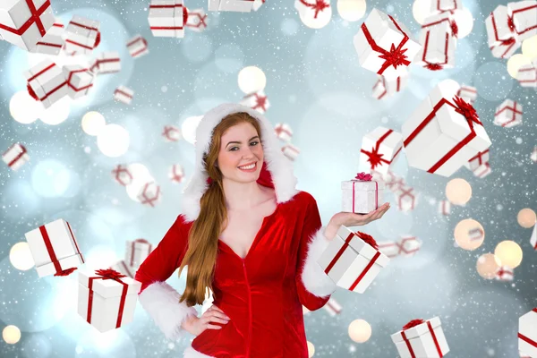 Imagen compuesta de chica bonita en traje de santa celebración caja de regalo — Foto de Stock