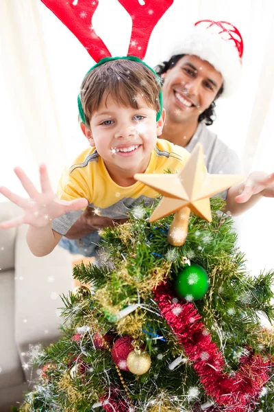 Vader en zoon versieren kerstboom Stockfoto