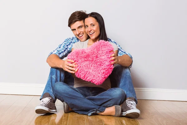 Pareja joven sentada en el suelo sonriendo —  Fotos de Stock