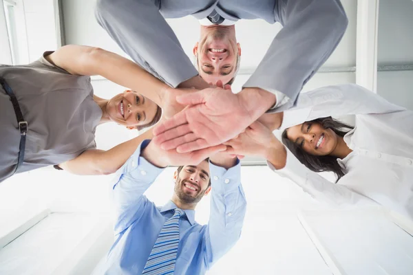 Cuatro trabajadores apilando manos juntos — Foto de Stock