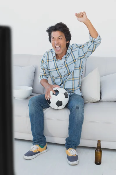 Soccer fan cheering while watching tv — Stock Photo, Image