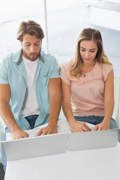 Pareja feliz usando sus computadoras portátiles —  Fotos de Stock