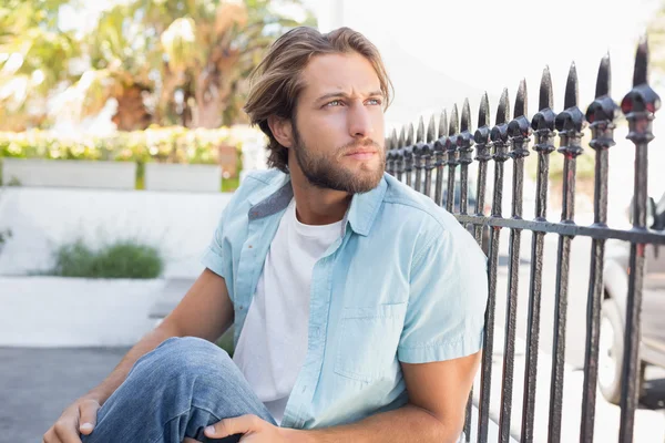 Lässiger Mann sitzt und denkt — Stockfoto