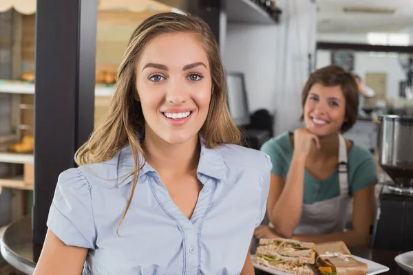 Mooie serveerster en klant glimlachen op camera — Stockfoto