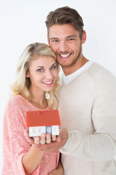 Atractiva pareja joven sosteniendo mini casa — Foto de Stock