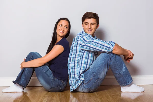 Jeune couple assis sur le sol — Photo