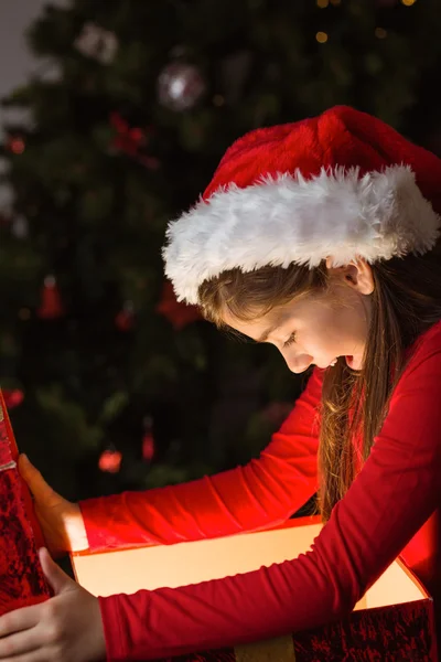 Menina abrindo um presente de Natal mágico — Fotografia de Stock