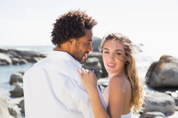 Gorgeous couple embracing by the coast — Stock Photo, Image