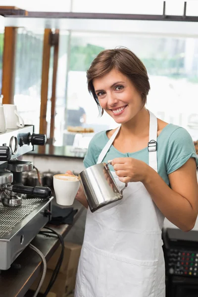 Ganska barista hälla mjölk i kopp kaffe — Stockfoto