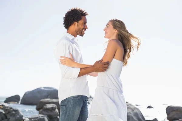 Gorgeous couple embracing at the coast — Stock Photo, Image