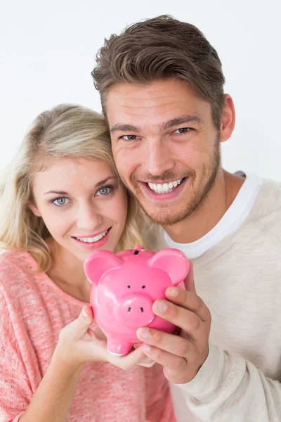 Attraktives junges Paar hält Sparschwein — Stockfoto