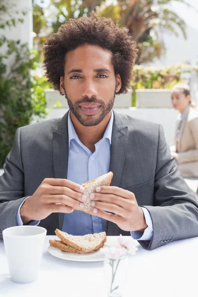 Επιχειρηματίας έχοντας σάντουιτς για μεσημεριανό γεύμα — Φωτογραφία Αρχείου