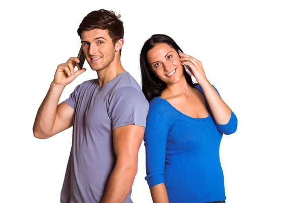 Giovane coppia parlando sui loro telefoni — Foto Stock