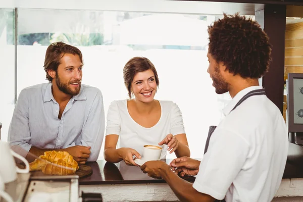 Barista serving two happy customers — Stock Photo, Image