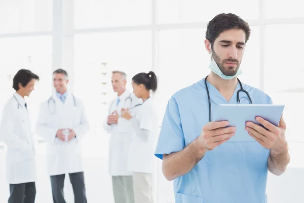 Seriöser Arzt schaut auf Tablet — Stockfoto