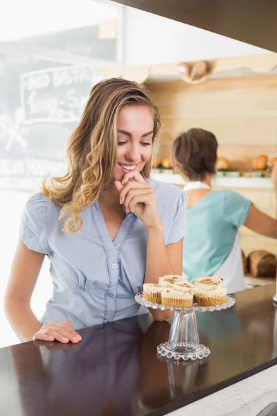 Mooie blonde wordt verleid door cupcakes — Stockfoto