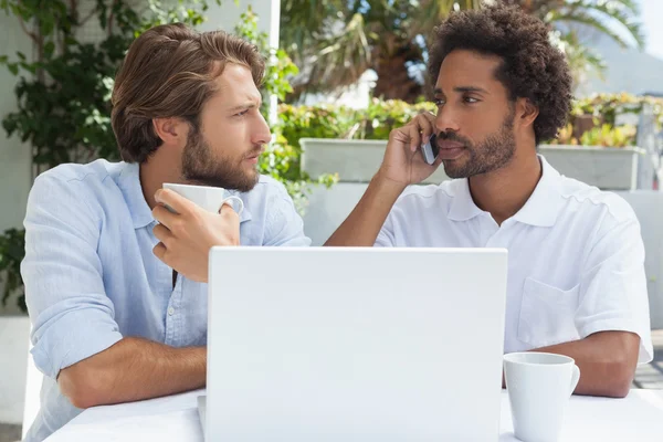 Dos amigos disfrutando del café junto con el ordenador portátil — Foto de Stock