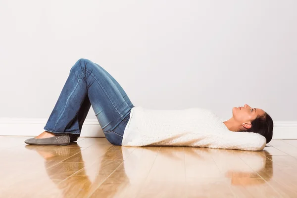 Mujer joven acostada en el suelo pensando — Foto de Stock