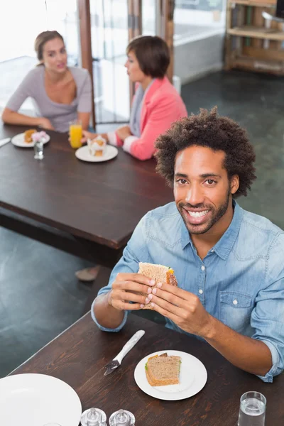 Hombre guapo comiendo un sándwich — Foto de Stock