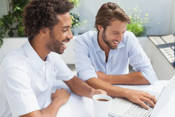 Due amici che si godono il caffè insieme al computer portatile — Foto Stock