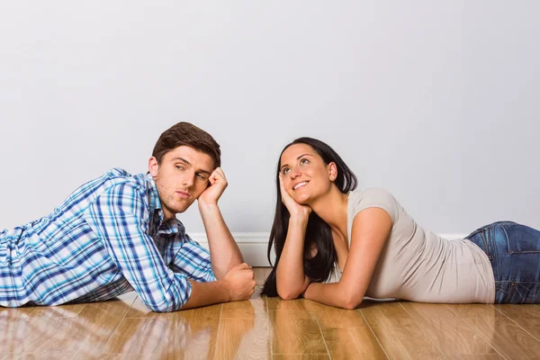 Giovane coppia sdraiata sul pavimento sorridente — Foto Stock