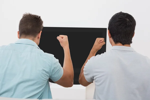 Dos aficionados al fútbol emocionados viendo la televisión — Foto de Stock