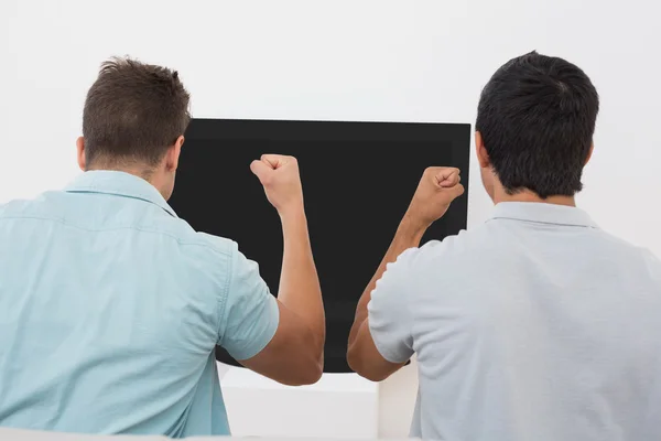 Two excited soccer fans watching tv — Stock Photo, Image