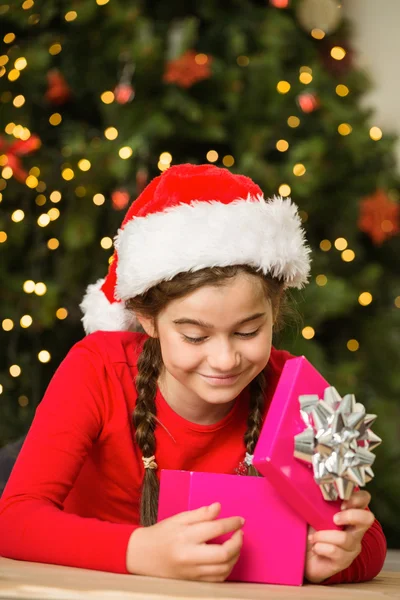 Kleines Mädchen öffnet ein Geschenk zu Weihnachten — Stockfoto