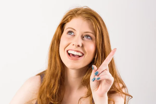 Pretty redhead pointing and looking up — Stock Photo, Image