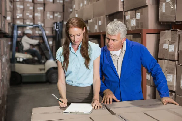 Magazijnbeheerder en foreman samen te werken — Stockfoto