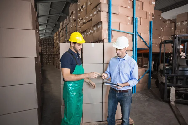 Warehouse worker loading up pallet with manager — Stock Photo, Image