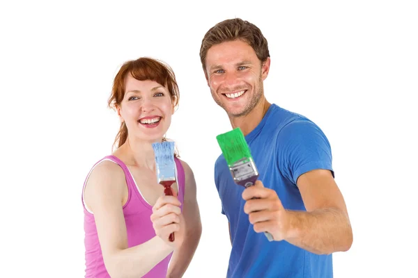 Couple both holding paint brushes — Stock Photo, Image