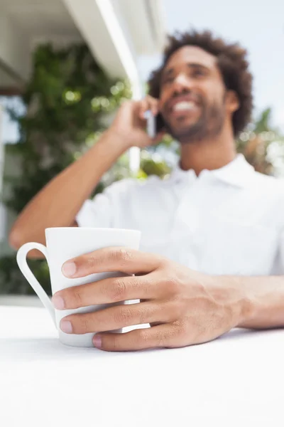 Lächelnder Mann am Telefon beim Kaffee — Stockfoto