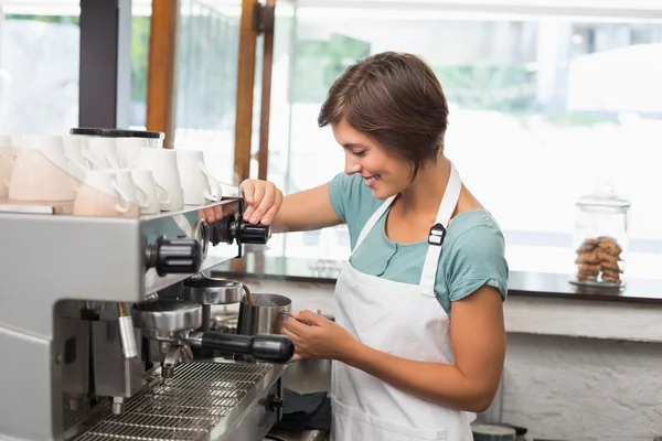 Pretty barista steaming jug of milk at coffee machine — Stock Photo, Image