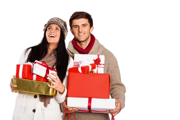 Молодая пара со многими рождественскими подарками — стоковое фото