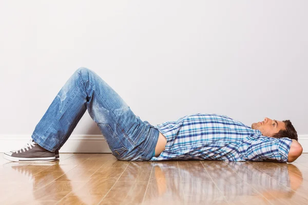 Young man lying on floor thinking — Stock Photo, Image