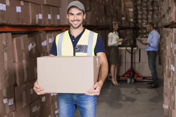 Warehouse worker carrying box — Stock Photo, Image