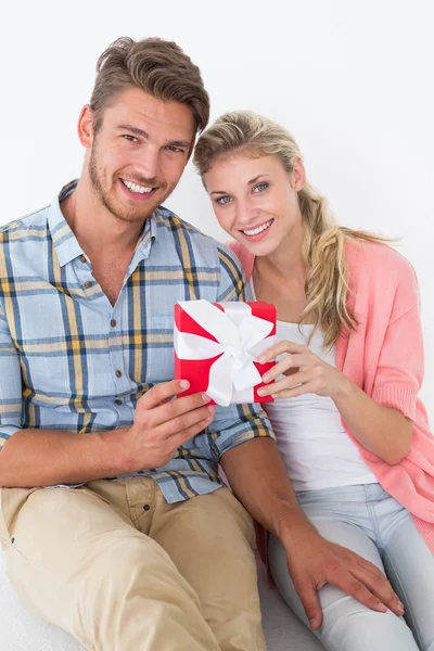 Atraente jovem casal segurando presente — Fotografia de Stock