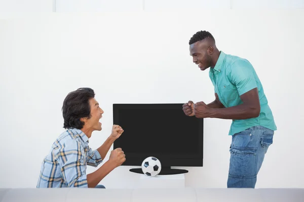 Dos aficionados al fútbol emocionados viendo la televisión — Foto de Stock