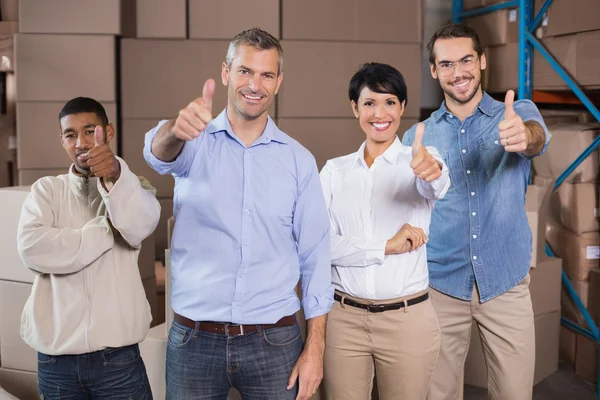 Trabajadores del almacén sonriendo a la cámara — Foto de Stock