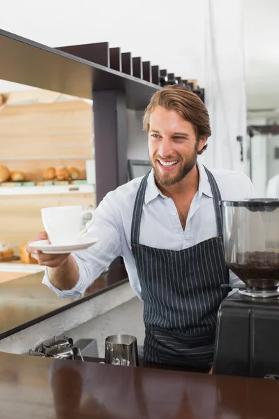Knappe barista biedt een kopje koffie — Stockfoto