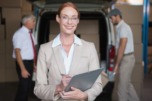 Warehouse manager writing in clipboard — Stock Photo, Image