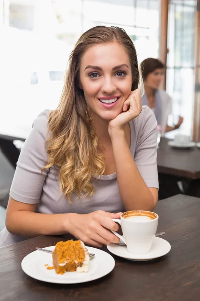 Mooie blonde genieten van cake en koffie — Stockfoto